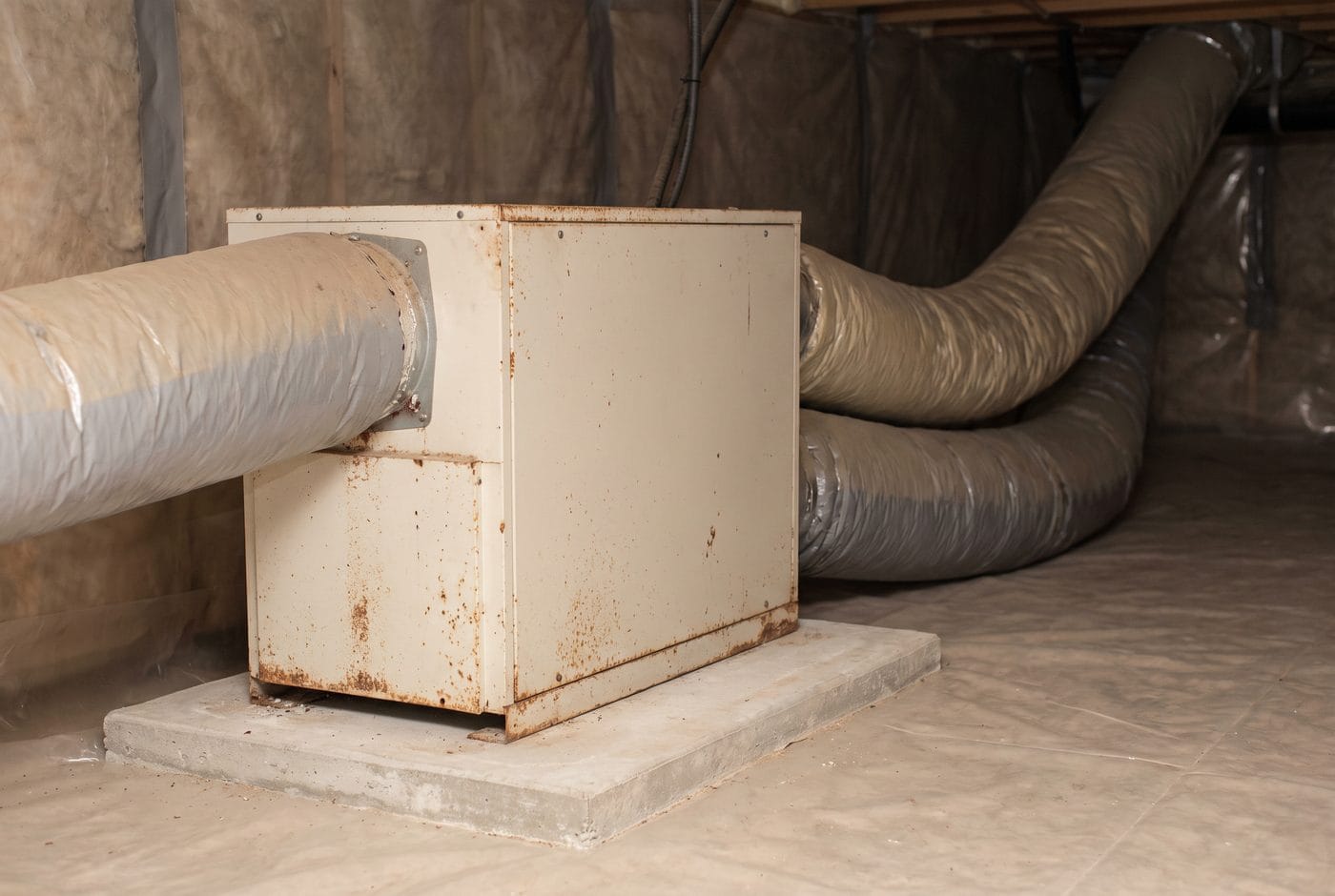 A whole-house dehumidifier installed in a crawlspace with insulated ducting to the return.